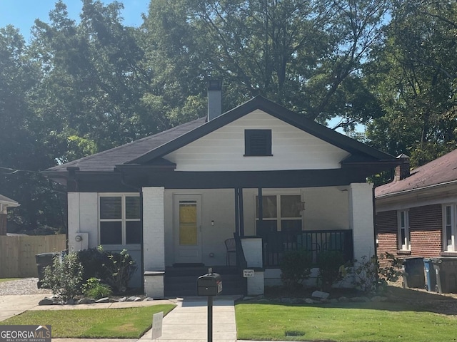 bungalow featuring a porch and a front lawn