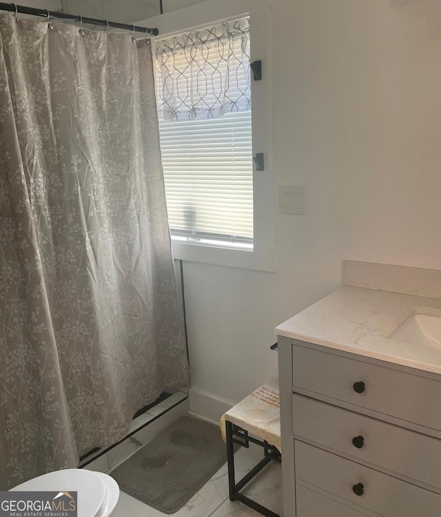 bathroom featuring walk in shower, vanity, toilet, and plenty of natural light