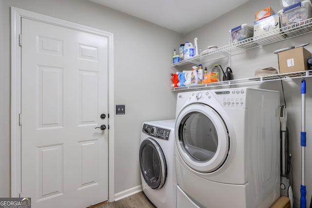 clothes washing area featuring independent washer and dryer and wood-type flooring