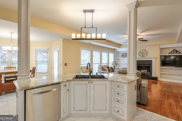 kitchen featuring light hardwood / wood-style floors, dishwasher, hanging light fixtures, sink, and decorative columns