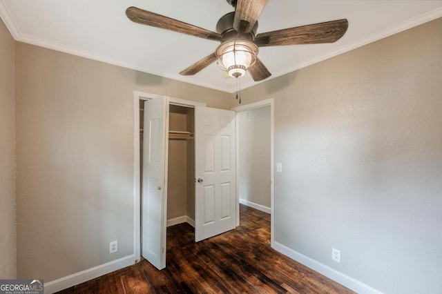 unfurnished bedroom with dark wood-type flooring, ceiling fan, crown molding, and a closet