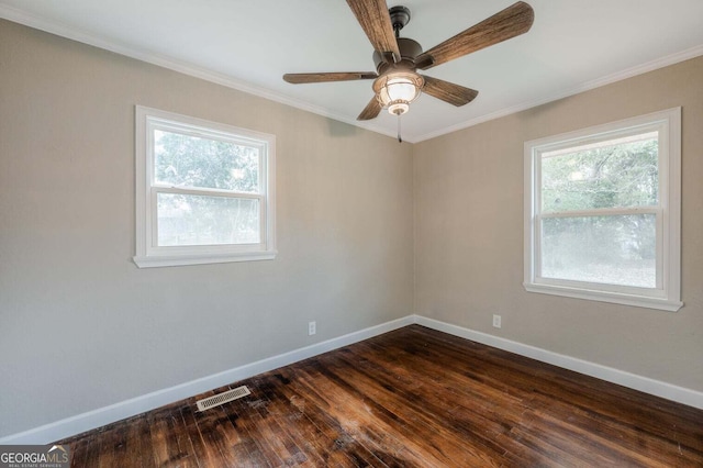 spare room with a wealth of natural light, ornamental molding, dark hardwood / wood-style floors, and ceiling fan