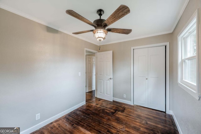 unfurnished bedroom featuring dark hardwood / wood-style flooring, a closet, ornamental molding, and ceiling fan