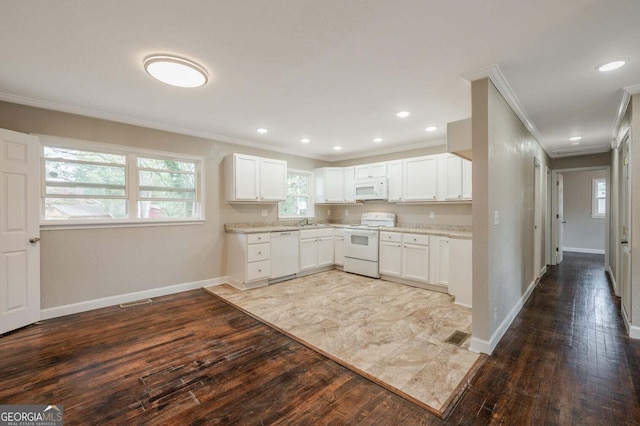 kitchen with white cabinets, hardwood / wood-style flooring, crown molding, sink, and white appliances