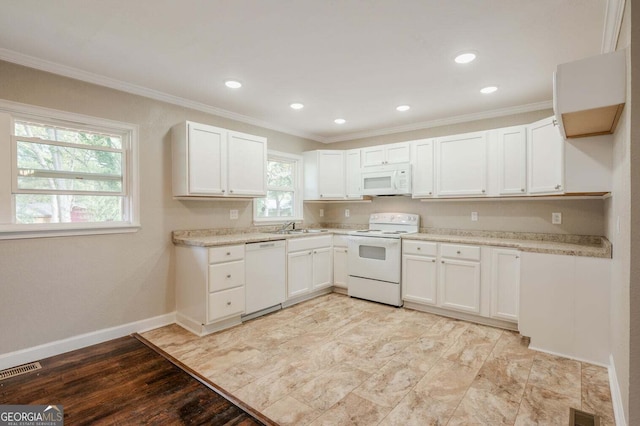 kitchen with white appliances, a healthy amount of sunlight, white cabinetry, and sink