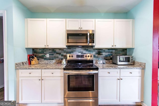 kitchen featuring appliances with stainless steel finishes, white cabinetry, and tasteful backsplash