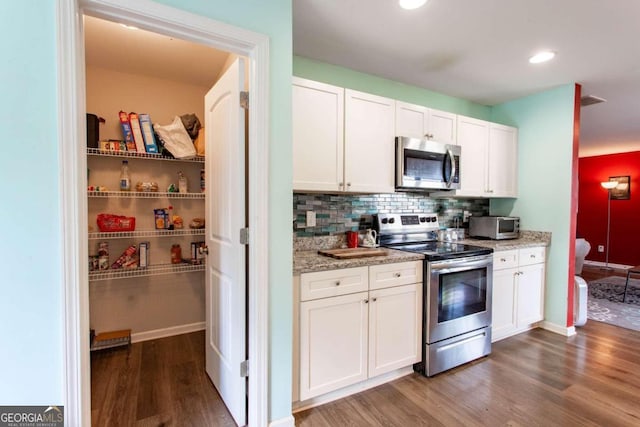 kitchen featuring white cabinetry, tasteful backsplash, stainless steel appliances, and dark hardwood / wood-style flooring