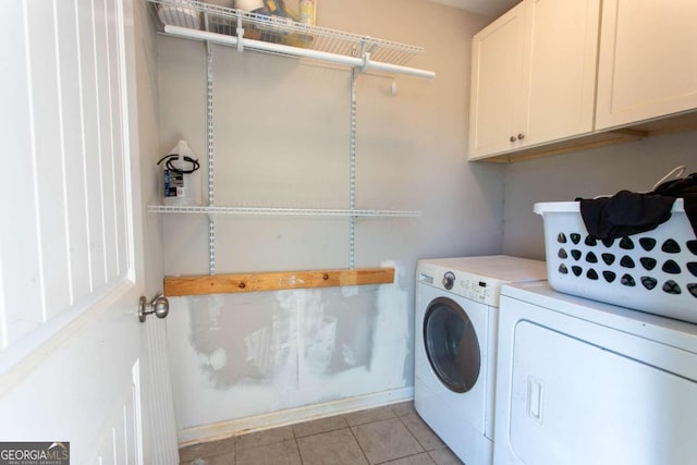 laundry area with cabinets, washing machine and dryer, and light tile patterned floors