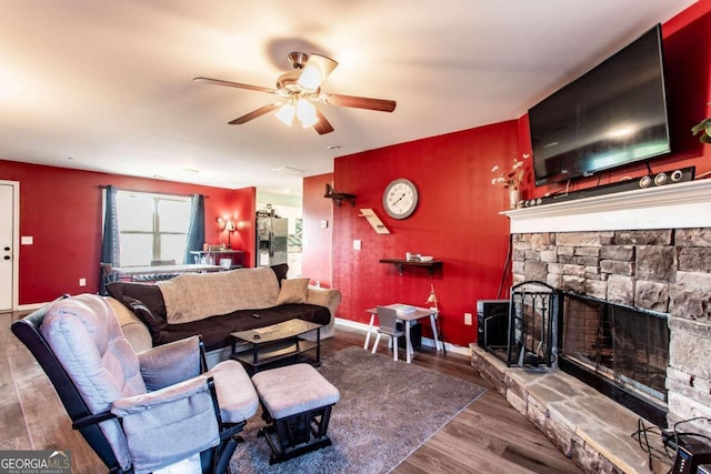 living room with a fireplace, wood-type flooring, and ceiling fan