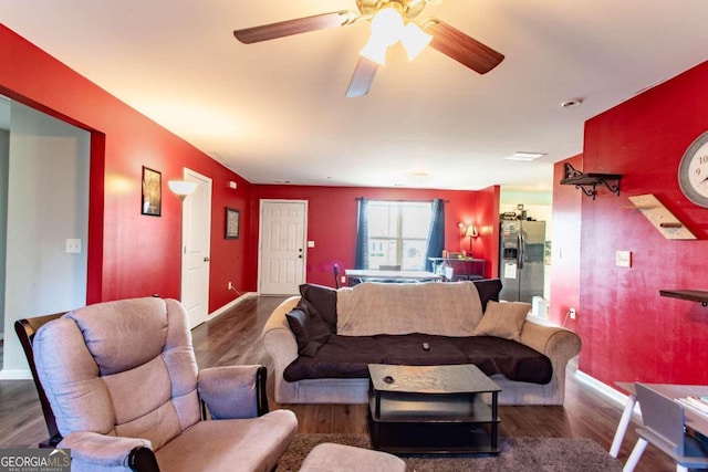 living room featuring ceiling fan and dark hardwood / wood-style flooring