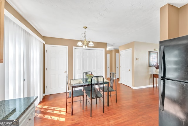 dining area featuring an inviting chandelier, hardwood / wood-style floors, and a textured ceiling