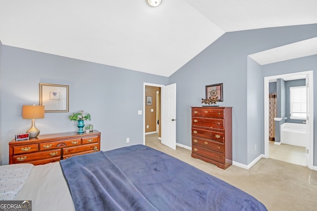 bedroom featuring connected bathroom, light carpet, and lofted ceiling