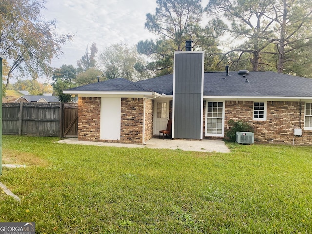 back of property with cooling unit, a lawn, and brick siding