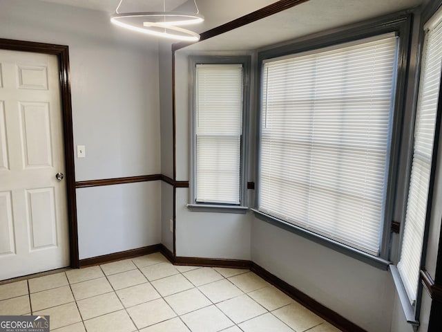 empty room featuring light tile patterned flooring and baseboards