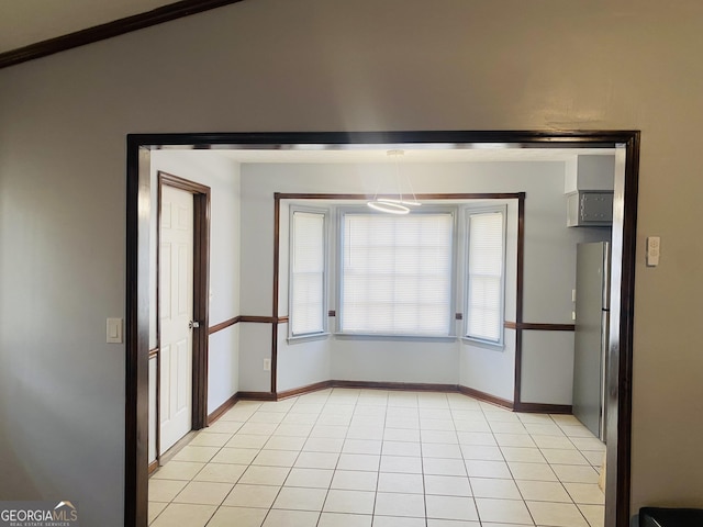 empty room featuring light tile patterned floors and baseboards