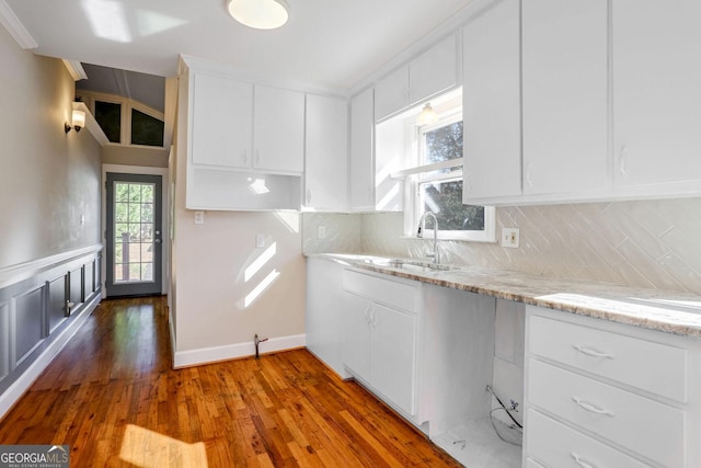 kitchen featuring white cabinetry, sink, tasteful backsplash, and light stone countertops