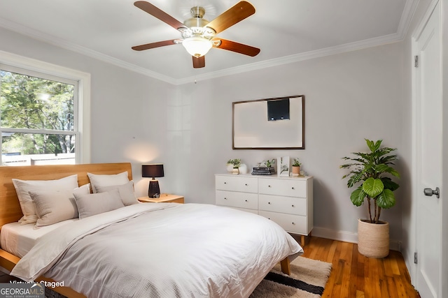 bedroom featuring ceiling fan, ornamental molding, and hardwood / wood-style floors