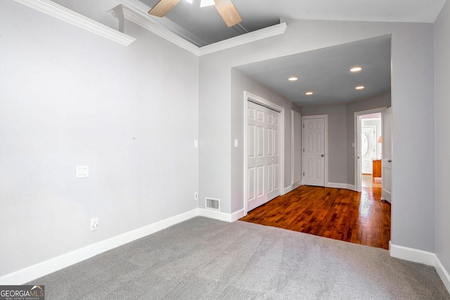 unfurnished room featuring vaulted ceiling, crown molding, ceiling fan, and dark carpet