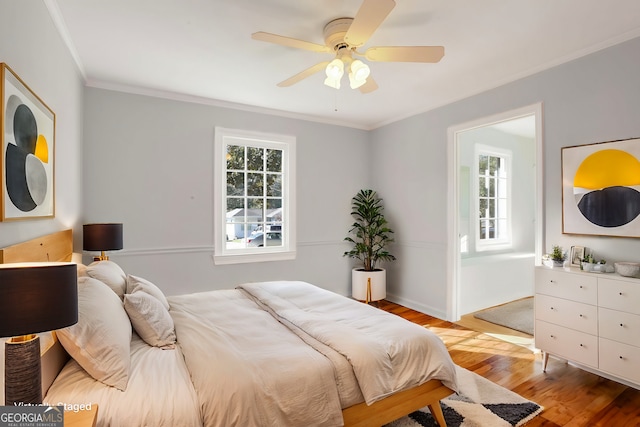 bedroom with ceiling fan, ornamental molding, and light hardwood / wood-style flooring