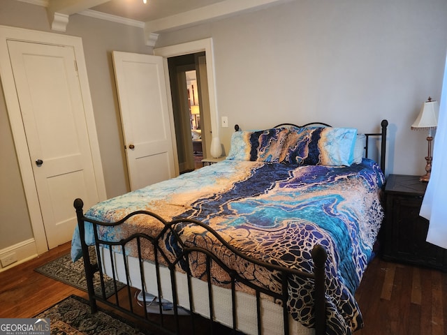 bedroom with a closet, ornamental molding, and dark wood-type flooring