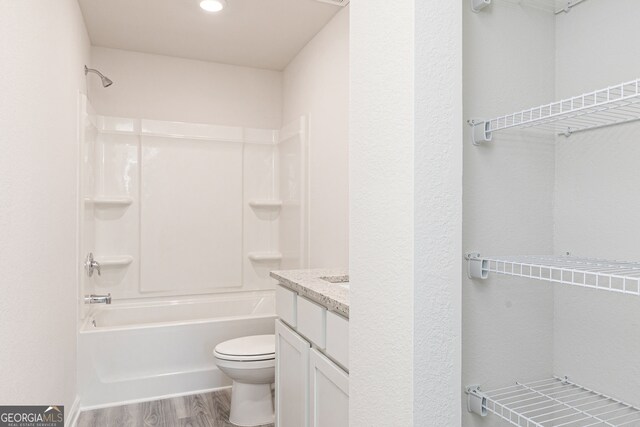 full bathroom featuring toilet, hardwood / wood-style flooring, vanity, and shower / bathtub combination