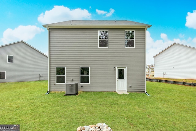 back of house featuring a yard and central AC unit