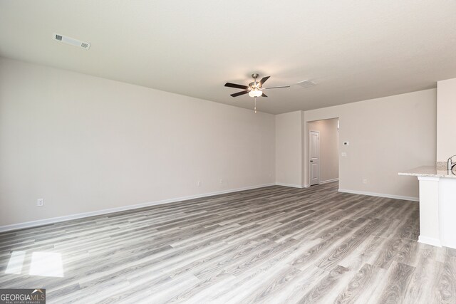 unfurnished living room featuring ceiling fan and light wood-type flooring