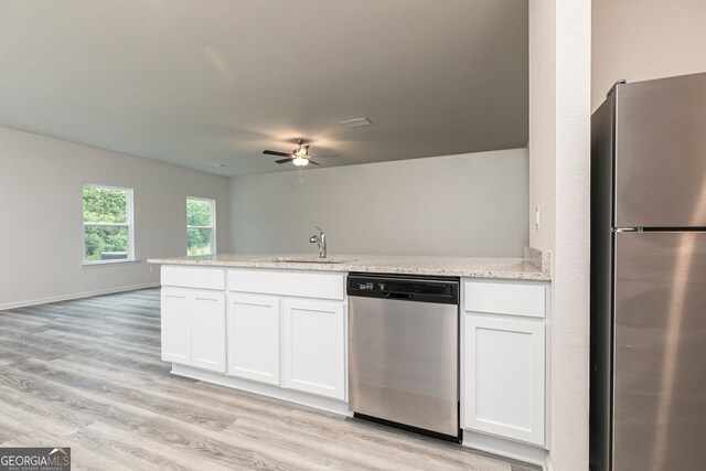 kitchen with stainless steel appliances, sink, light wood-type flooring, white cabinetry, and ceiling fan