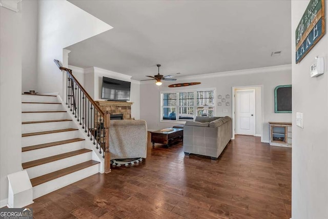 living room with crown molding, dark hardwood / wood-style flooring, a fireplace, and ceiling fan