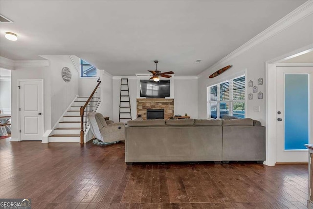 living room featuring ornamental molding, ceiling fan, a fireplace, and dark hardwood / wood-style flooring