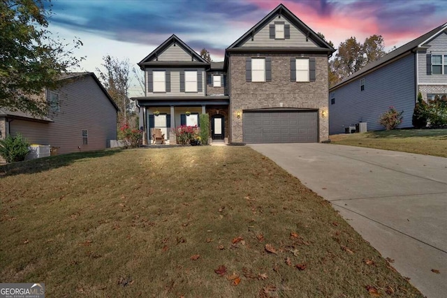 view of front of home with a yard, central air condition unit, a porch, and a garage