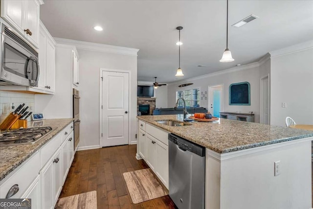 kitchen featuring white cabinets, appliances with stainless steel finishes, a kitchen island with sink, dark hardwood / wood-style floors, and sink