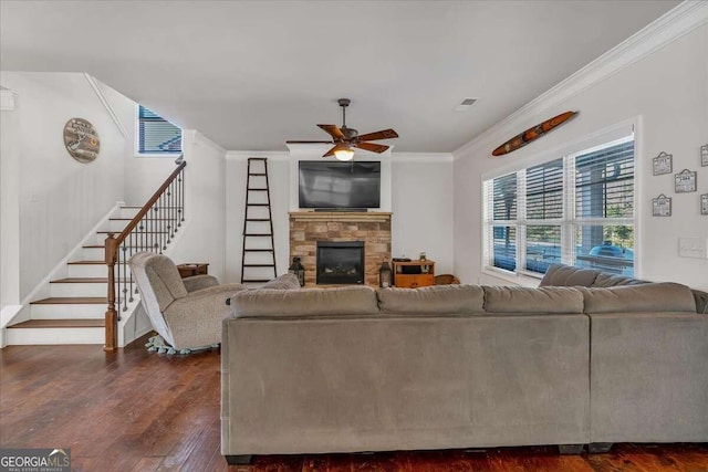 living room featuring crown molding, a fireplace, dark hardwood / wood-style floors, and ceiling fan