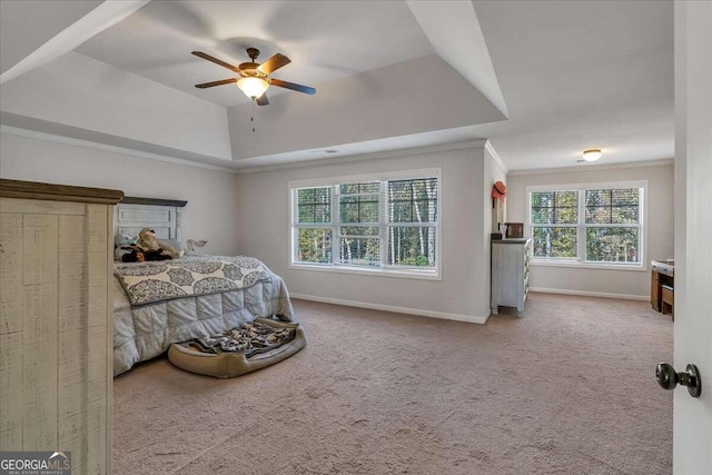 bedroom with ceiling fan, crown molding, a raised ceiling, and light colored carpet