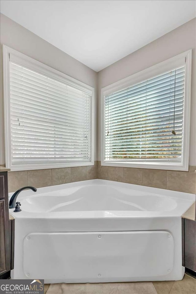 bathroom featuring tile patterned floors and a bath