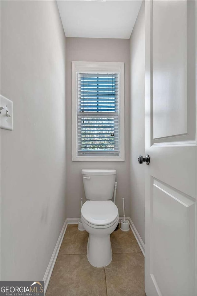 bathroom with toilet and tile patterned flooring