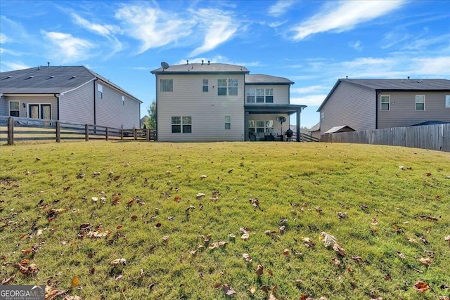 rear view of property featuring a lawn