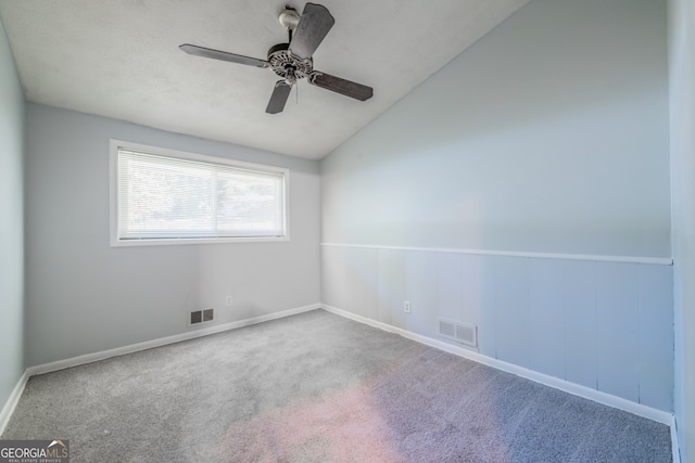 carpeted empty room with ceiling fan and lofted ceiling