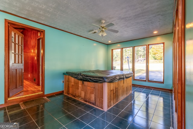 misc room featuring a jacuzzi, a textured ceiling, dark tile patterned floors, and ceiling fan