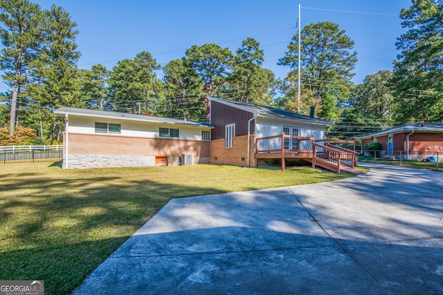 view of front of home featuring central AC, a front lawn, and a deck