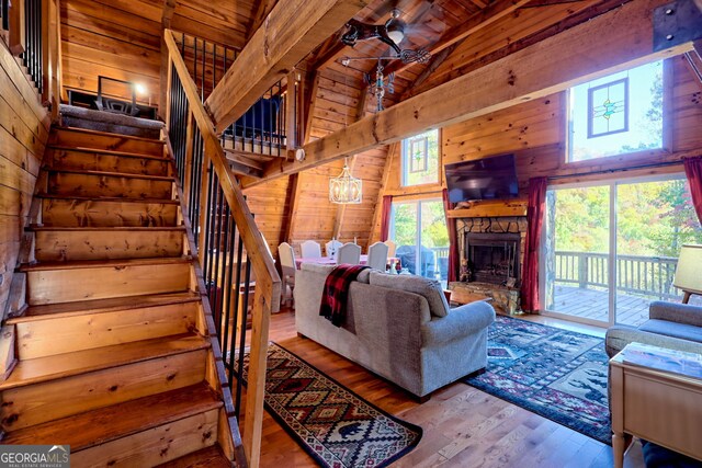 living room featuring light hardwood / wood-style floors, wood walls, wooden ceiling, and beam ceiling