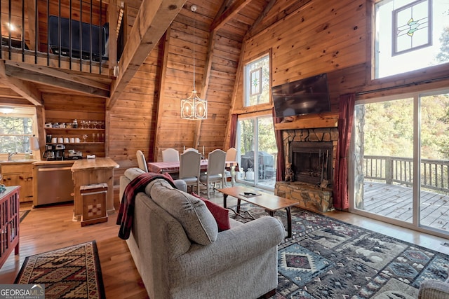 living room with wood ceiling, light hardwood / wood-style flooring, a notable chandelier, high vaulted ceiling, and wood walls