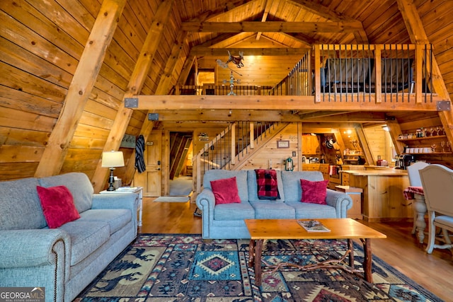 living room featuring hardwood / wood-style flooring, beamed ceiling, wooden ceiling, high vaulted ceiling, and wood walls