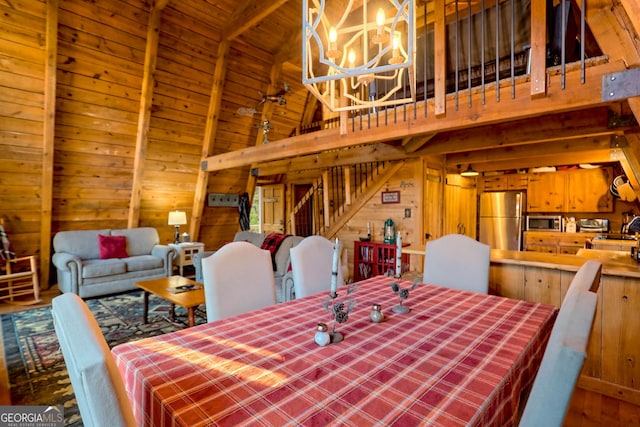 dining room featuring wood ceiling, beam ceiling, a chandelier, high vaulted ceiling, and wood walls