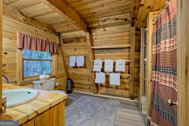 bathroom with wood ceiling, hardwood / wood-style flooring, toilet, wood walls, and beamed ceiling