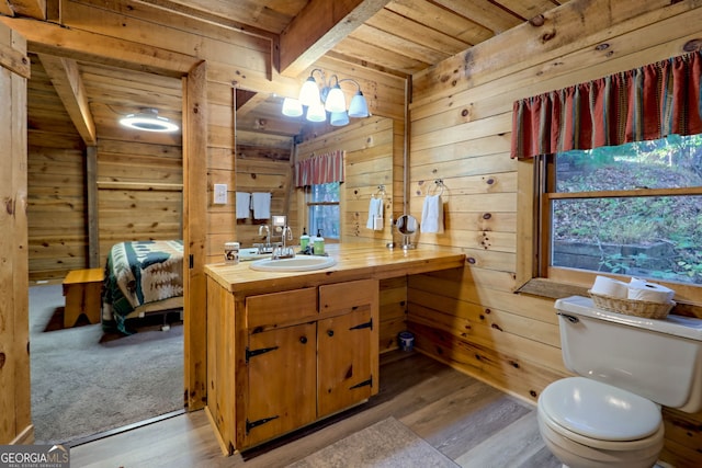 bathroom with toilet, a healthy amount of sunlight, and hardwood / wood-style floors