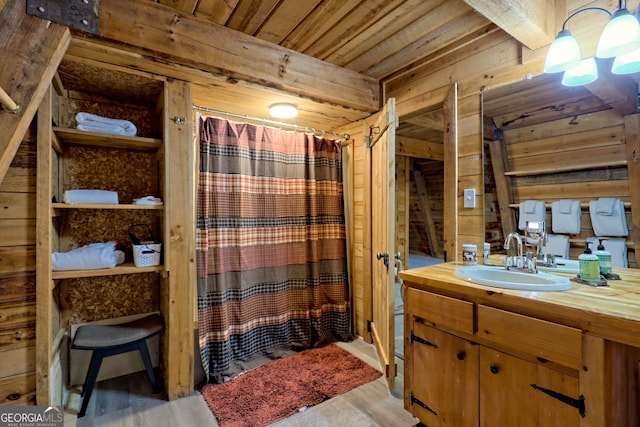 bathroom with wood ceiling, hardwood / wood-style floors, vanity, wooden walls, and a shower with shower curtain