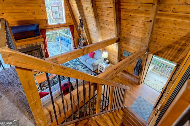 staircase featuring wood ceiling, wood walls, beam ceiling, and hardwood / wood-style floors