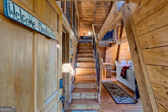 stairs with wooden ceiling and hardwood / wood-style floors