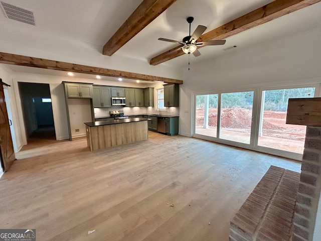 kitchen featuring sink, green cabinets, hardwood / wood-style flooring, stainless steel appliances, and decorative backsplash